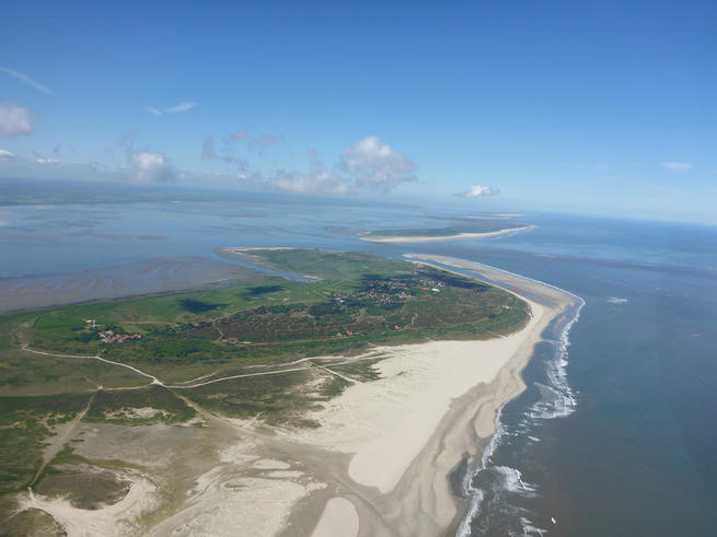 Die Küste verändert sich ständig. Hier die Nordwestseite von Spiekeroog, mit Langeoog und Baltrum im Hintergrund. <span>Nick Rüssmeier/Universität Oldenburg</span>