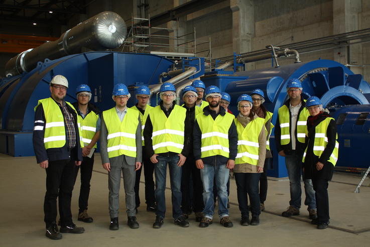 Jürgen Volkens (li., Ingenieur der ENGIE SA) mit den Exkursionsteilnehmern vor der Turbine des Steinkohlekraftwerks <span>Foto: Jade HS/Oliver Niesen</span>