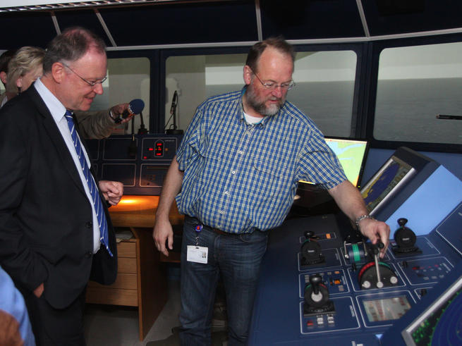 Klaus Damm (re.), technischer Leiter des Schiffsführungssimulators, erklärt Ministerpräsident Weil die Funktion des Simulators. <span>Foto: Piet Meyer</span>