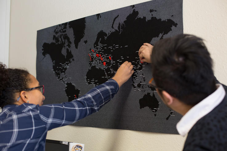 Julia Lüder und Yen Shan zeigen sich gegenseitig auf der Weltkarte, welche Länder sie gerne bereisen möchten. (Foto: Jade HS/Bonnie Bartusch)