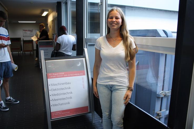 Marieke Walter wartet vor dem Immatrikulationsamt, um sich für den Studiengang Maschinenbau einzuschreiben.