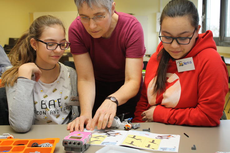 Karin Volck (mi) erklärt Vanessa (li) und Xenia (re), wie sie ihren Roboter zusammenbauen können.