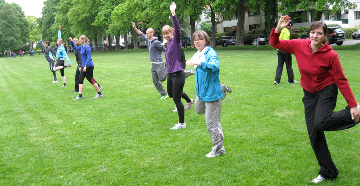 Die Teilnehmer der Laufgruppe wärmen sich auf der Dobbenwiese auf.