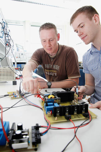 Die Studierenden Stefan Gundlach (li.) und Alex Erfurt (re.) arbeiten an ihren Bachelor-Projekten im Bereich Leistungselektronik. Ein anschließendes Master-Studium können sie sich gut vorstellen. <span>Foto: Geert Oeser</span>